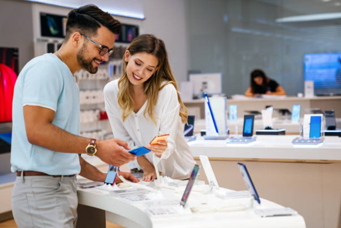 Modern devices showing Tech Shopping Trends 2026, including laptops, phones, TVs, and audio systems.