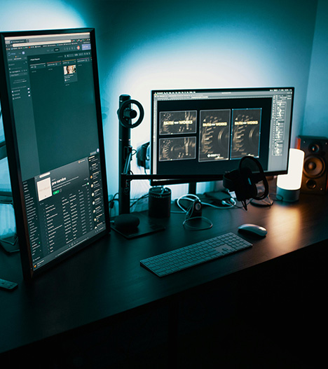 An office workspace with a large table for a shared workspace, with computer keyboards and screens positioned near chairs.
